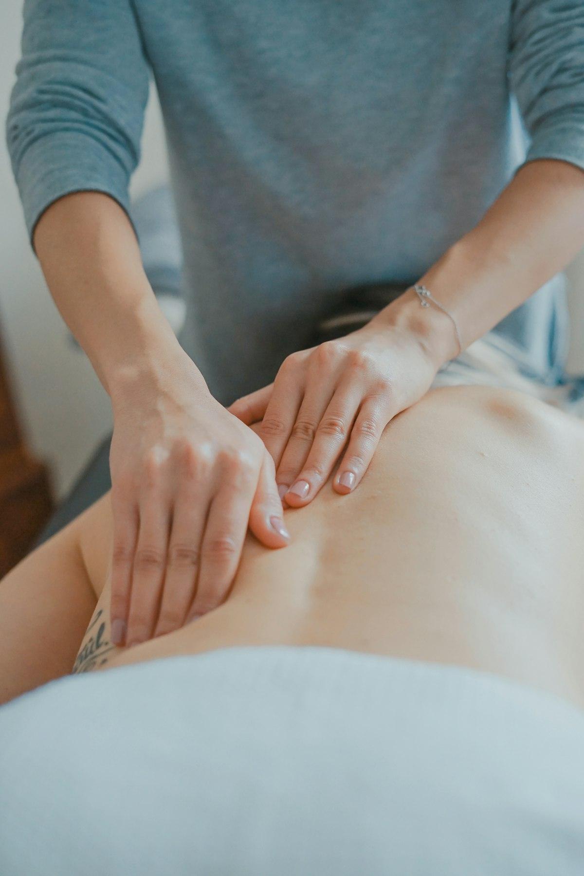 Manuelle Therapie am Rücken, Hände auf der Haut
