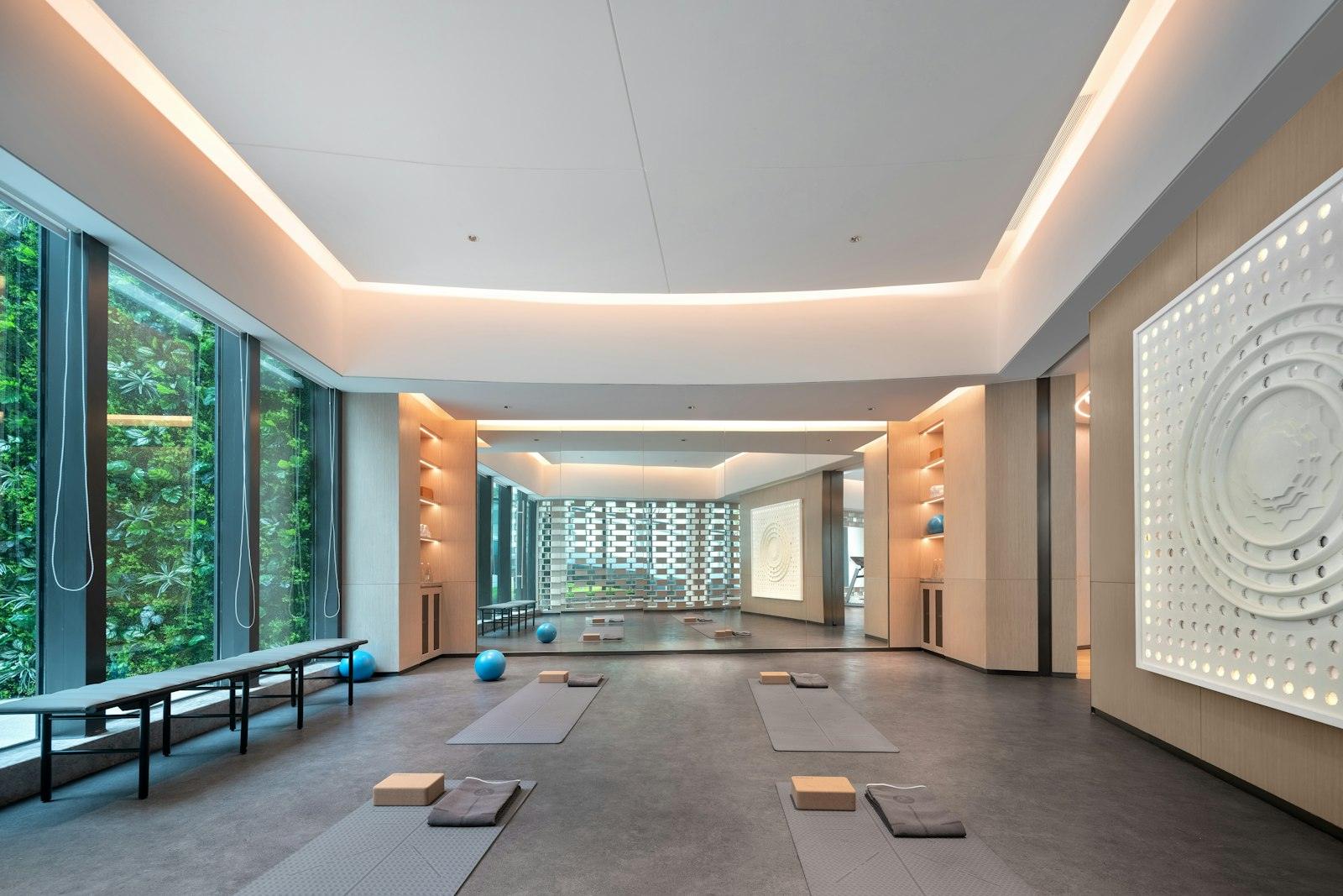 Heller Trainingsraum mit großen Fenstern und Matten